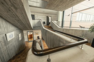 Modern staircase with concrete and wooden details, open structure and interior decoration,