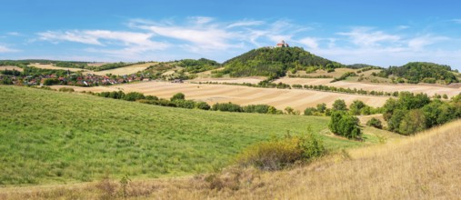 View over hilly landscape with meadows, fields and forests of Wachsenburg Castle and the village of