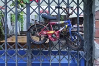 Old children's bicycle on an iron grid, Krakow, Poland