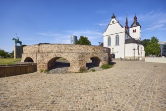 Historic railway hub, Alt St. Heribert church, equestrian statue, cobblestone walkway, lawn, trees,