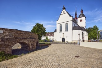Historic railway hub, Alt St. Heribert church, cobblestone walkway, trees, pedestrians as