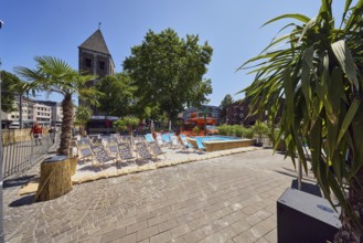 ColognePride Beach, beach club, deckchairs, palm trees, sandy area, swimming pool, church tower of