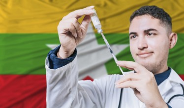Doctor holding syringe on Myanmar flag background. Medical professional holding syringe with