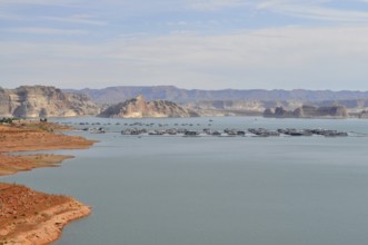 Peaceful water area of Lake Powell with floating houseboats and mountain scenery, Arizona, USA