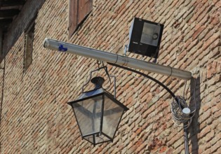 Historic lantern and modern halogen spotlight in La Rocca, Novellara Castle, Emilia-Romagna, Italy