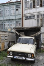 Tbilisi, Georgia. July 7th 2025. An old Eastern European car parked outside some traditional