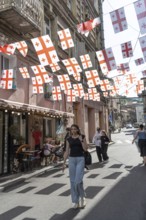 Tbilisi, Georgia. July 7th 2025. Georgian flags flutter over a side street in the Old Town in