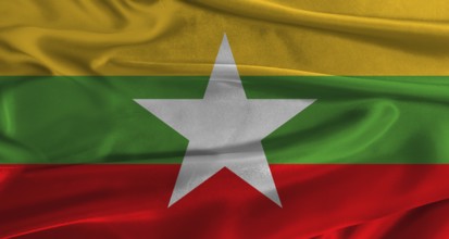 Flag of Myanmar with fabric textured background. Close up of National flag of Myanmar with