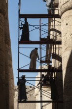 Luxor, Egypt. December 12th 2022 Silhouetted local Egyptian workers cleaning and restoring the