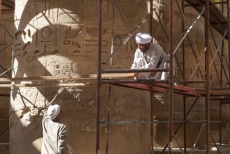 Luxor, Egypt. December 12th 2022 Local Egyptian workers cleaning and restoring the ancient columns