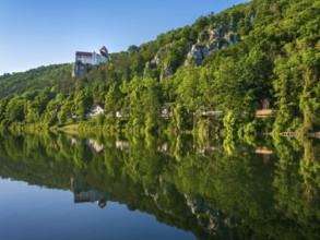 Prunn Castle on steep rock above the Altmühl Valley in the evening light, reflection in the river
