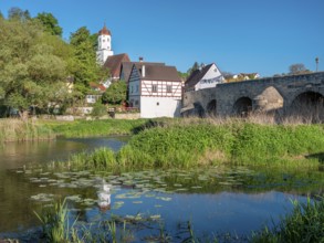 View across the Wörnitz river to the old town with the medieval stone bridge and church, Harburg,