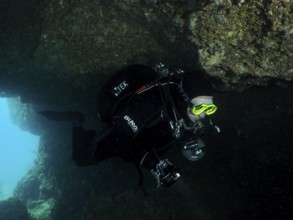 Diver, cave diver, in the dark area of an underwater cave wears diving equipment. Fraskeric dive