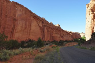 A narrow road snakes through impressive red rock walls in a dry desert landscape, Grand Staircase