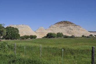 Green meadow with view of rocky mountains under clear sky, Grand Staircase Escalante National