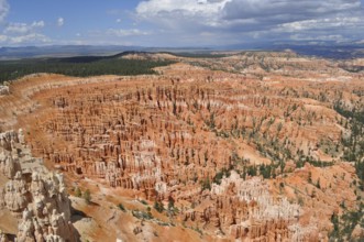 Wide rocky landscape under cloudy sky with orange canyons, Bryce Canyon National Park, Utah, USA