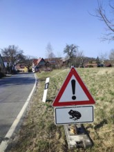 Caution sign with frog symbol (rana) on a rural road, animal protection in the Franconian Forest