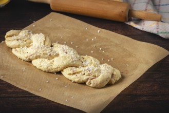 Braided yeast braid with sugar on baking paper