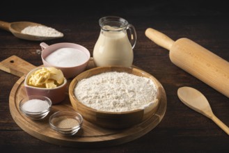 Baking ingredients and utensils such as a rolling pin, bowl of flour, sugar, butter and a pot of