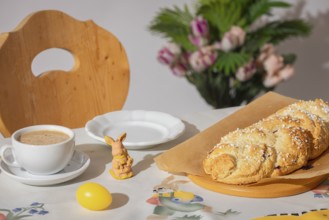 Breakfast table with coffee, yeast braid and decoration for Easter