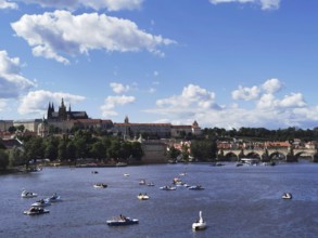Summer hustle and bustle on the Vltava in Prague with Charles Bridge and Hradcany in the