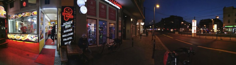 Panorama Lively evening street scene with illuminated snack bar and urban atmosphere, Pankow,