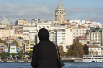 Istanbul, Turkey. November 10th 2022 A Muslim women looks out over the Golden Horn towards the