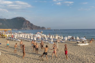 Holiday makers playing volleyball on Cleopatra Beach in the Turkish holiday resort town of Alanya
