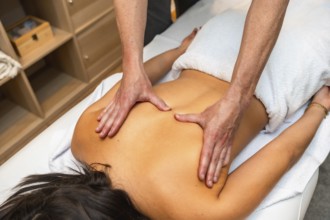 Hands of a professional therapist giving a deeply relaxing and therapeutic back massage to a woman