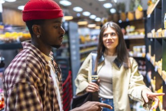 Diverse young couple selecting fresh produce in a modern supermarket aisle, comparing options and