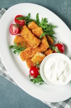 Fried fish nuggets, with white sauce, arugula and cherry, no people
