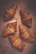 Fresh croissants, breakfast, top view, on the table, brown background, no people