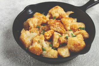 Fried cauliflower, with spices and herbs, in a cast-iron pan, homemade, no people