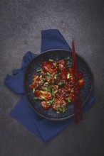 Yakitori chicken kebab, on a plate, with green onions and sesame seeds, top view, no people