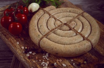 Raw spiral sausages, on a wooden board, top view, no people