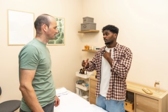 Two men in a counseling session engage in serious, supportive conversation in a clinical office,
