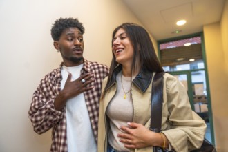 Two young adults, a black man and a caucasian woman, engaging in a lively conversation, sharing a