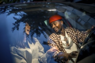 Happy interracial couple sharing a laugh while driving, reflecting joy and freedom on their