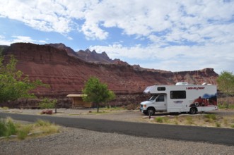 Motorhome standing in a rocky landscape with red rocks and partly cloudy sky, Grand Canyon National