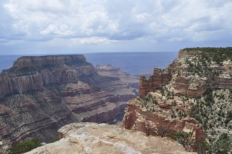 Deeply cut rock canyons with dramatic cliffs under a cloudy sky, Grand Canyon National Park,
