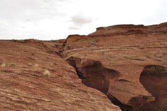 Wide rocky landscape with heavily eroded sandstone formations and a cloudy sky, Antelope Canyon,