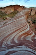 People on a striped rock formation snaking through the desert, Valley of Fire State Park, Nevada,