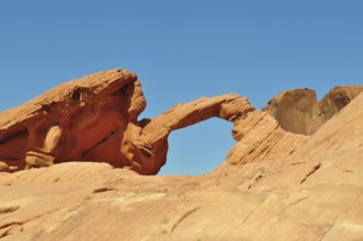 Majestic red sandstone arch under clear blue desert sky, Valley of Fire State Park, Nevada, USA