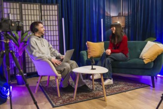 Diverse young content creators recording a podcast or social media video, sitting in a modern