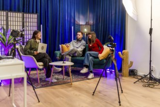 Group of young content creators smiling and interacting while recording a podcast or video