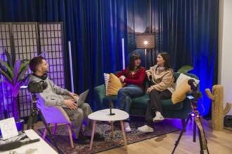 Young multiethnic creators collaborating on a podcast and social media video in a modern studio