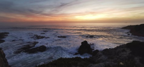 Sunset over the sea, gentle waves and rocks in a tranquil atmosphere, hiking on the Fisherman's