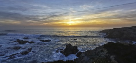 A breathtaking sunset over the sea with dramatic waves and rocks, hiking the Fisherman's Trail,