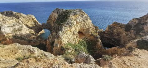 Archway, dramatic rock formations overlooking the calm blue sea, Lagos, Algarve, Portugal