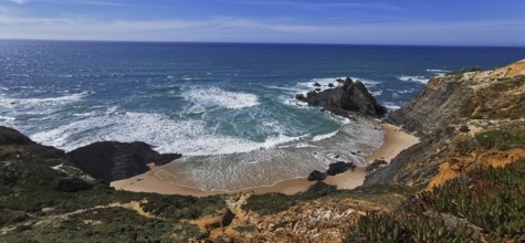 Waves break on a secluded sandy beach surrounded by rocks under a clear sky, hiking the Fisherman's